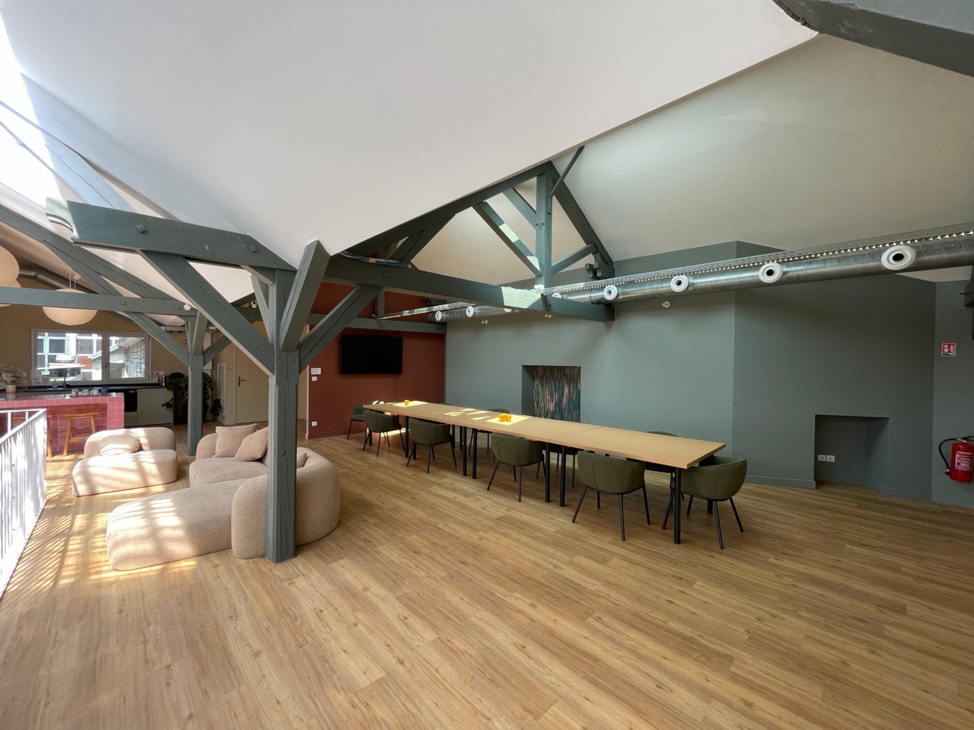 Salle de formation sous les combles du Comptoir Général, charpente apparente et grande table