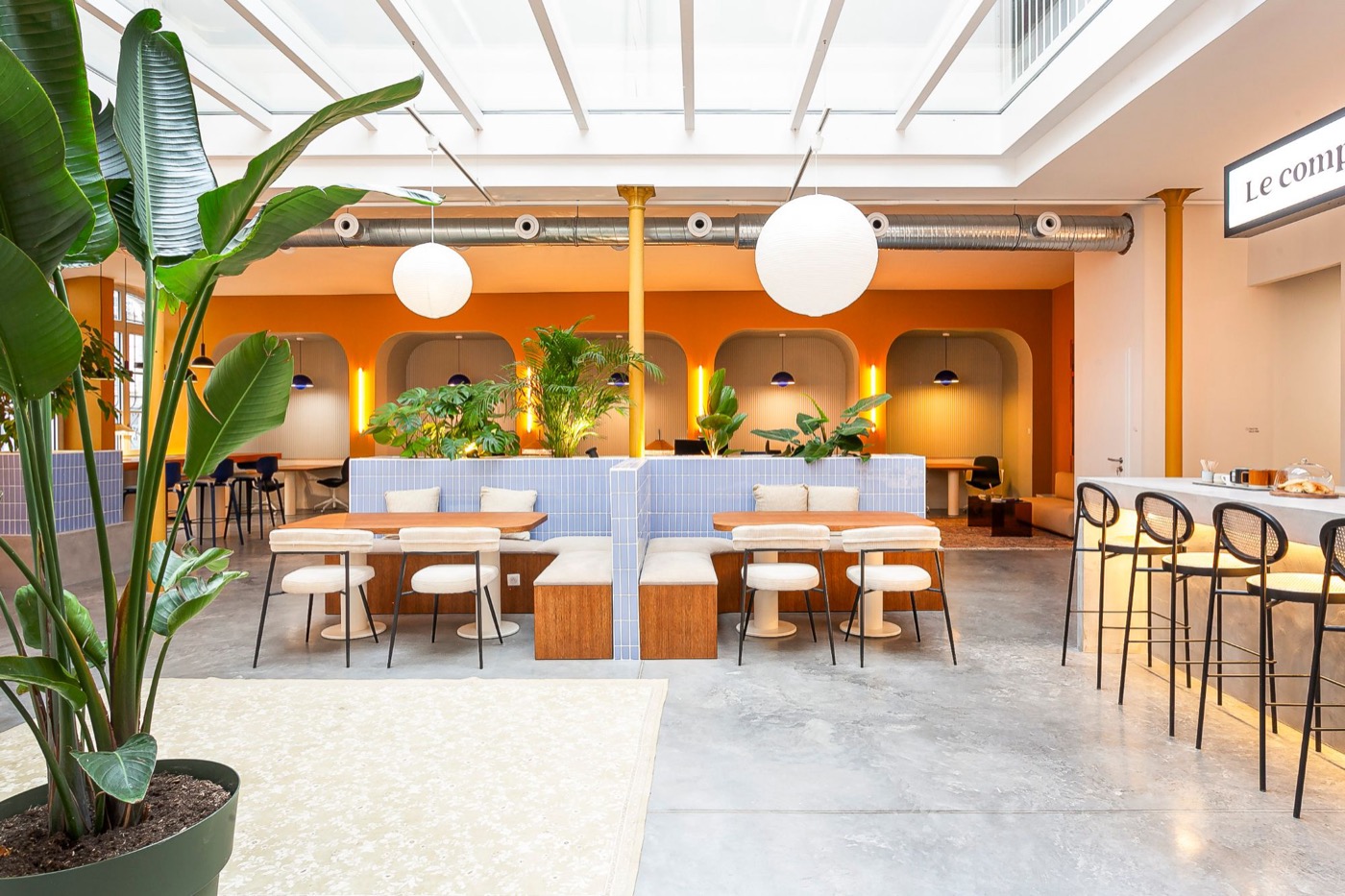 Espace de coworking du Comptoir Général sous verrière, alcôves et banquettes