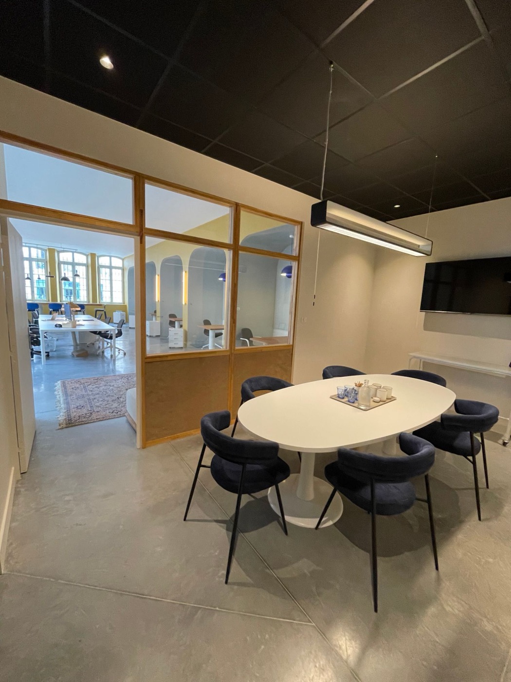 Salle de réunion du Comptoir Général, table ovale et fauteuils bleu nuit